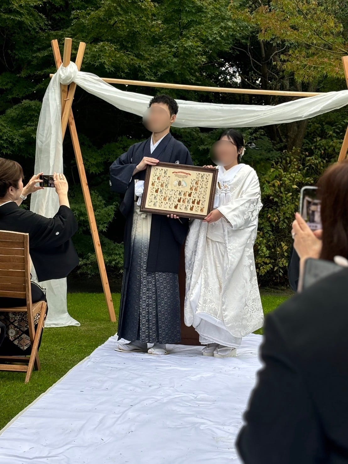 結婚証明書を手にするご夫婦(屋外での結婚式にて)